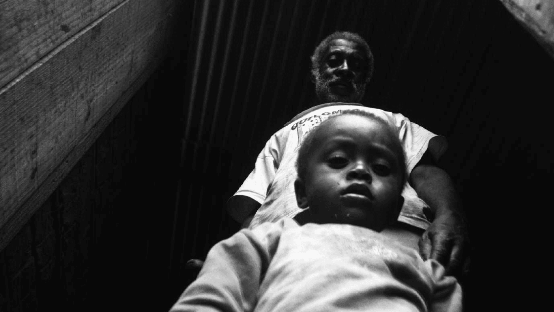 foto preto e branco de um bebê negro com seu avô negro